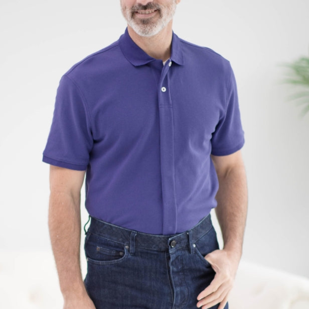 Man in a purple polo shirt paired with dark jeans, showcasing a casual and stylish look.