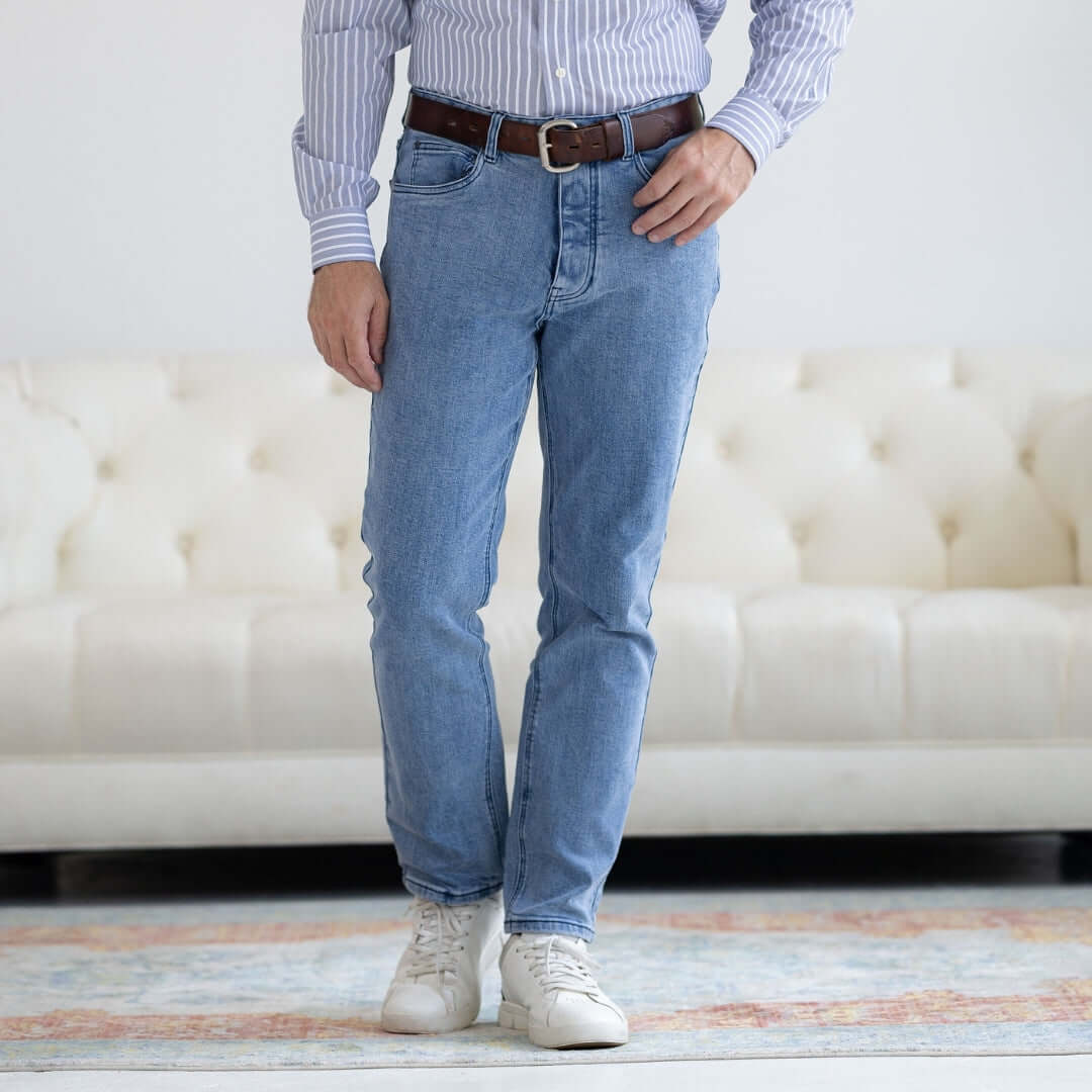 Person wearing blue jeans and a striped shirt in a living room setting