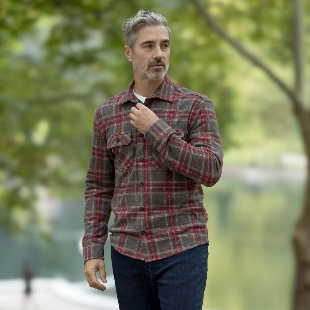 Man wearing an adaptive brown glen plaid flannel shirt outdoors, perfect for layering in changing seasons.