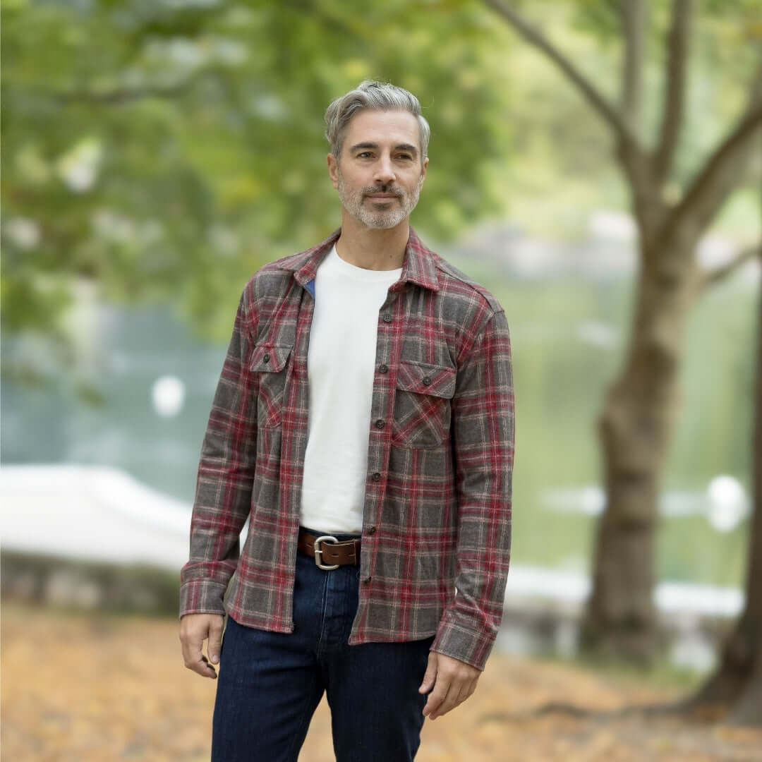 Man wearing an Adaptive Brown Glen Plaid Flannel Shirt, perfect for layering in autumn surrounded by nature.