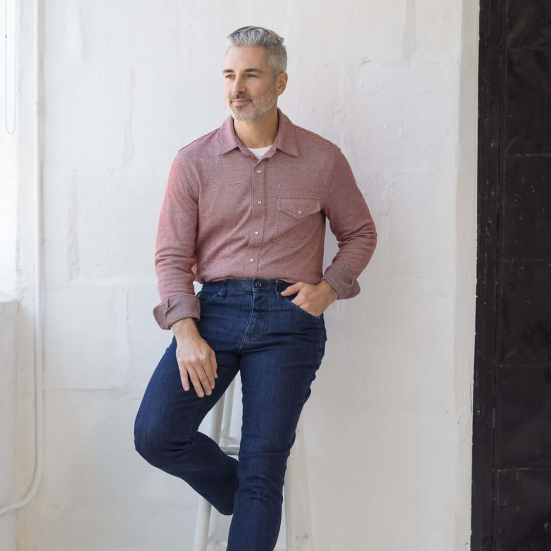 Man wearing adaptive casual Western knit twill shirt in Rio Red with magnetic buttons, sitting on a stool.