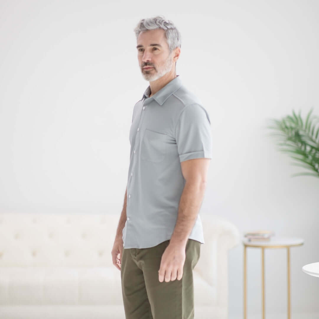 Man wearing adaptive cooling magnetic short sleeve shirt in grey, designed for individuals with limited mobility.