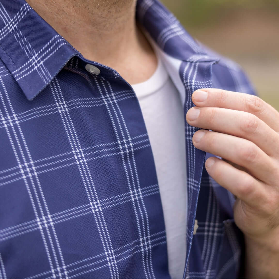 Adaptive Cooling Magnetic Front Short Sleeve Shirt in Navy Windowpane on a person adjusting the collar.