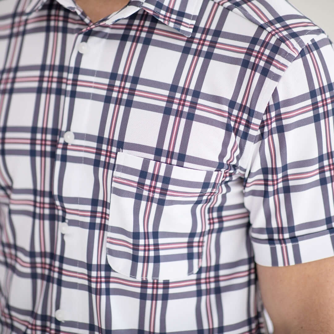 Close-up of a short-sleeve plaid shirt in navy and red with a pocket, highlighting its adaptive design.