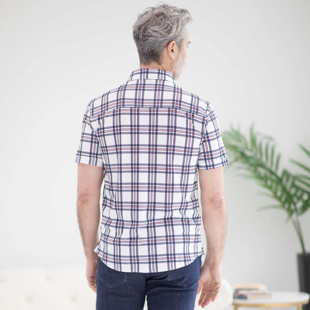 Back view of a man wearing a plaid short-sleeve shirt, showcasing its adaptive design for comfort and mobility.