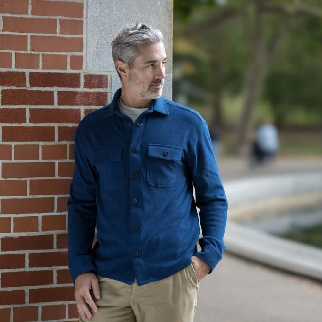 Man wearing an adaptive indigo flannel shirt combo jacket by a park's edge, showcasing versatility and style.