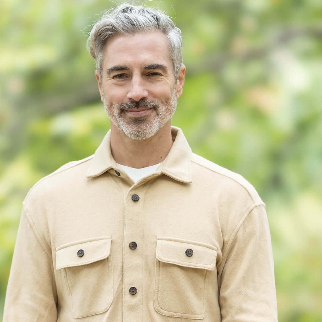Stylish man wearing a khaki flannel combo shirt with magnetic closures, perfect for layering in changing seasons.