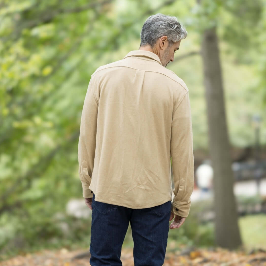 Man wearing khaki flannel shirt from back, perfect for layering in a natural outdoor setting.