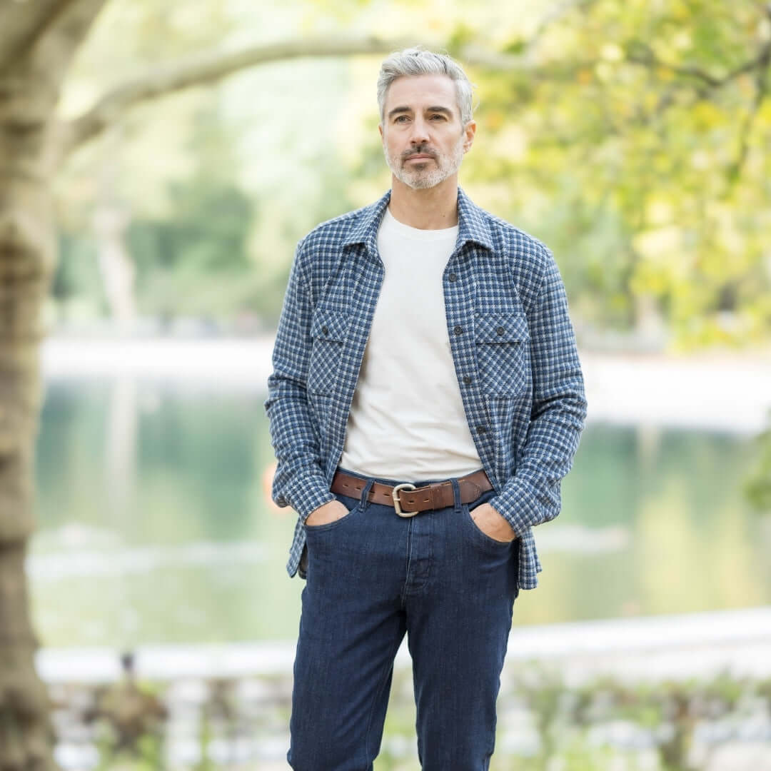 Man wearing an adaptive white and navy check flannel shirt, styled for a casual outdoor look.