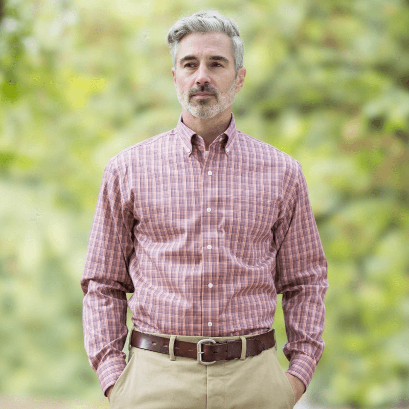 Man wearing a plaid button down shirt in an outdoor setting, showcasing a classic style with a relaxed fit.