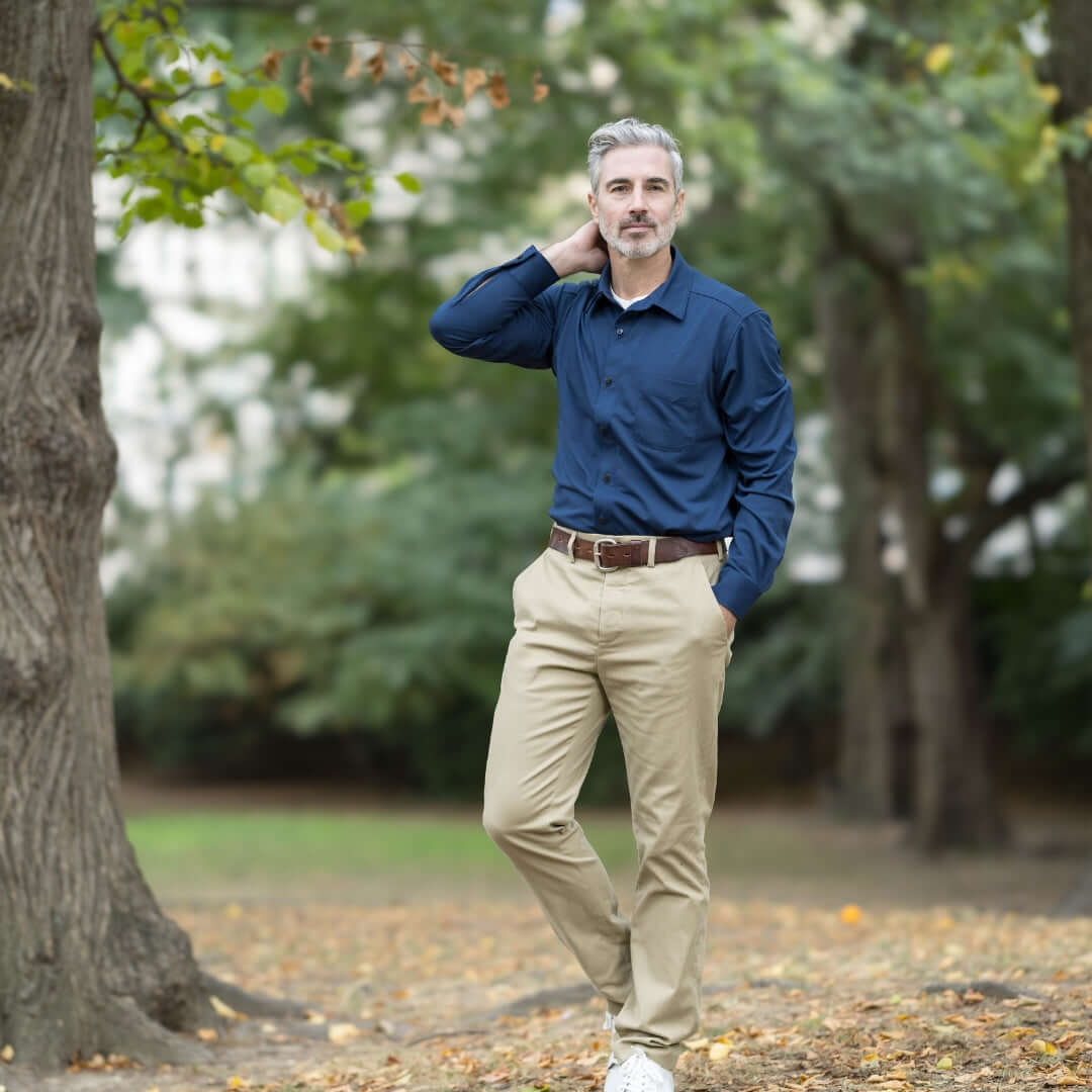 Man in true navy long sleeve magnetic polo standing outdoors in a casual pose.
