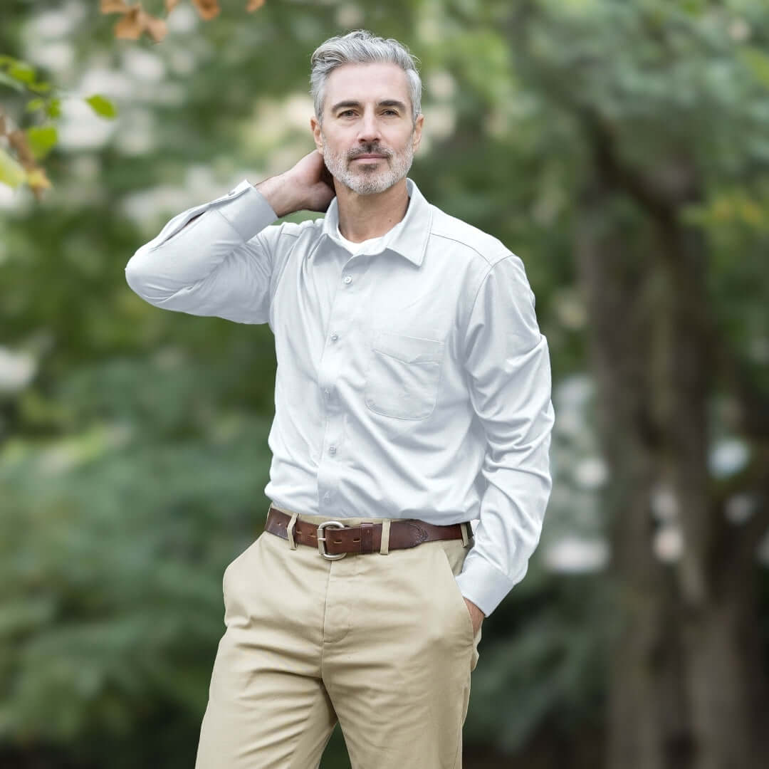 Adaptive White Magnetic Front Long Sleeve Cooling Adaptive Polo with Pocket modeled outdoors.