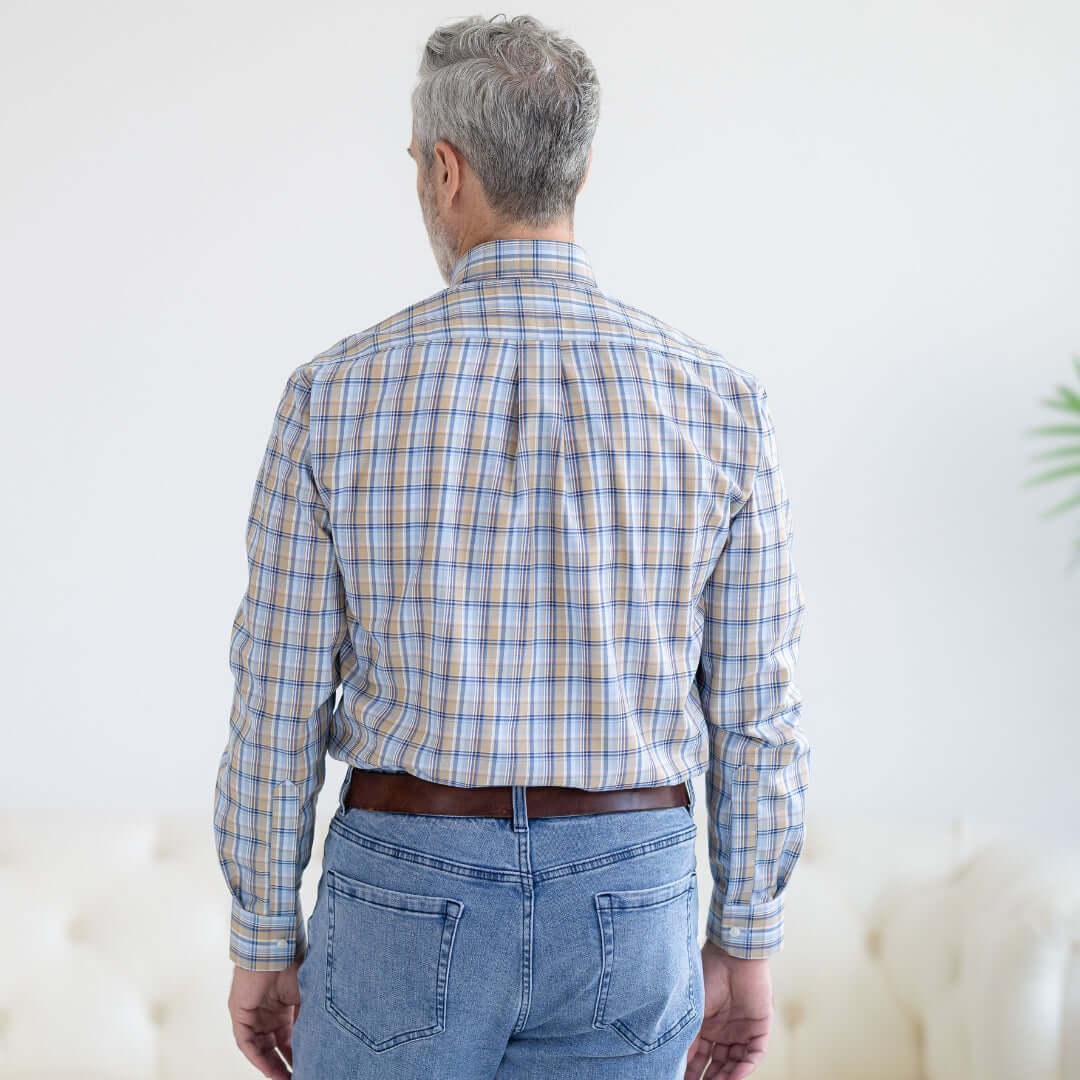 Back view of a man wearing a blue and brown plaid long sleeve button-down shirt with magnetic closures.
