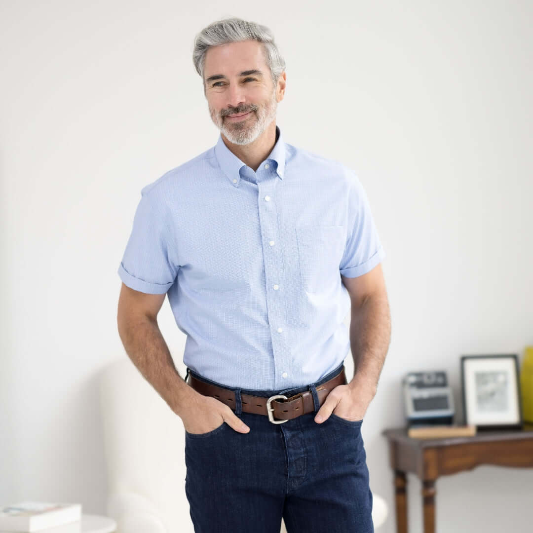Man wearing a blue check short sleeve button-down shirt, showcasing the MagnaReady adaptive design for easy wear.