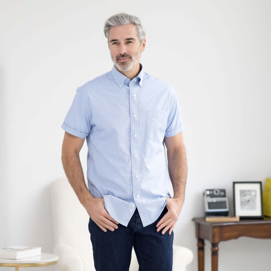 Man in blue check short sleeve button-down shirt with magnetic closures, designed for comfort and mobility.