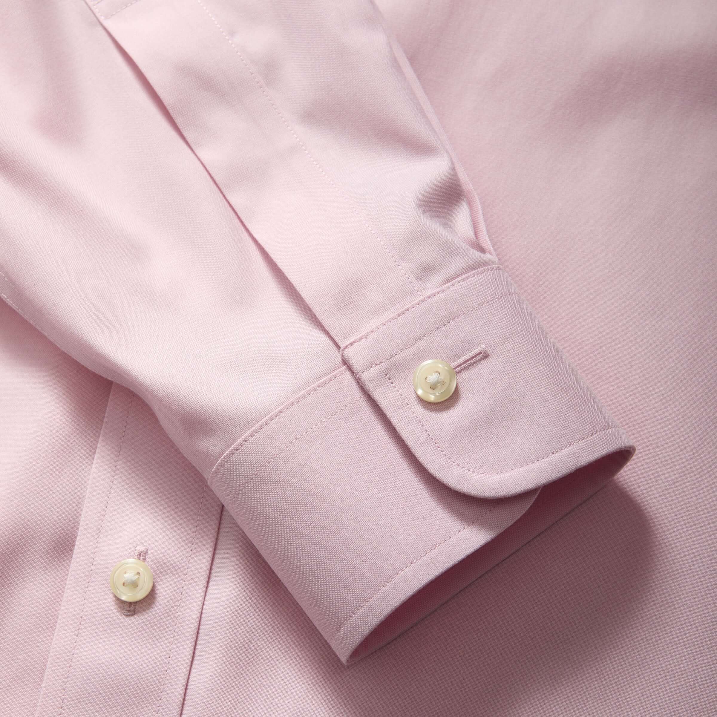 Close-up of the collar and cuff of a Brooks Brothers pink polo shirt, showcasing magnetic closures and elegant detailing.