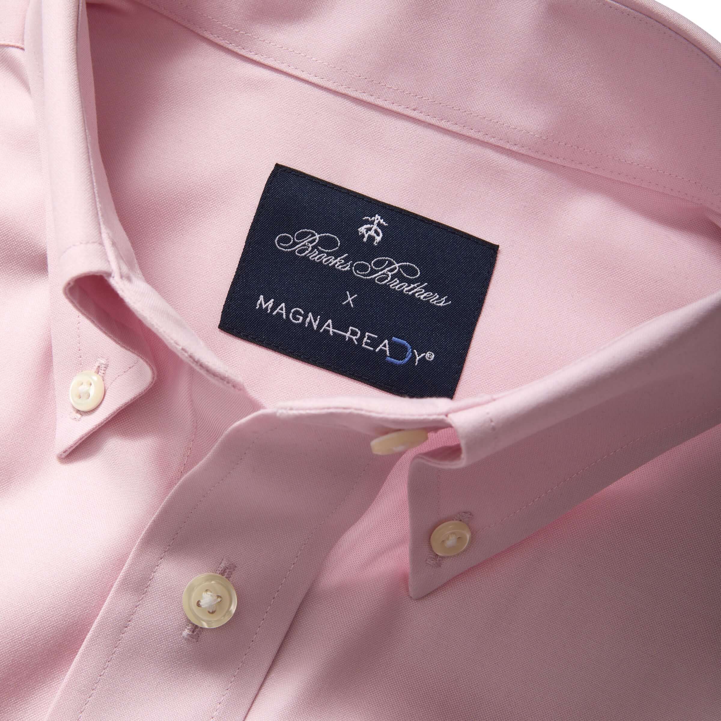 Close-up of Brooks Brothers x MagnaReady pink polo shirt collar and tag, featuring magnetic closures and classic styling.