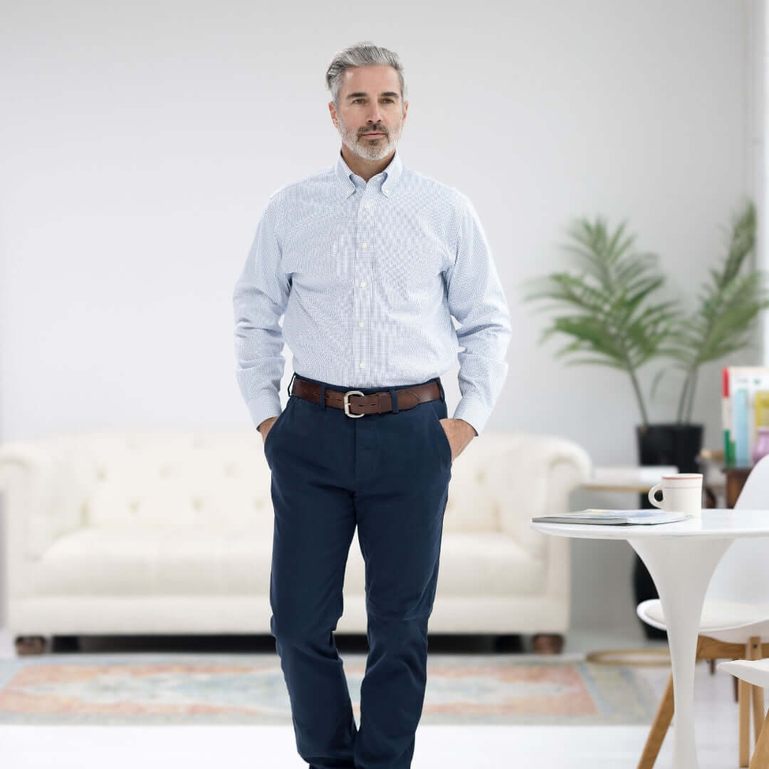 Man wearing Brooks Brothers x MagnaReady blue and white check button-down shirt with magnetic closures, styled with navy pants.