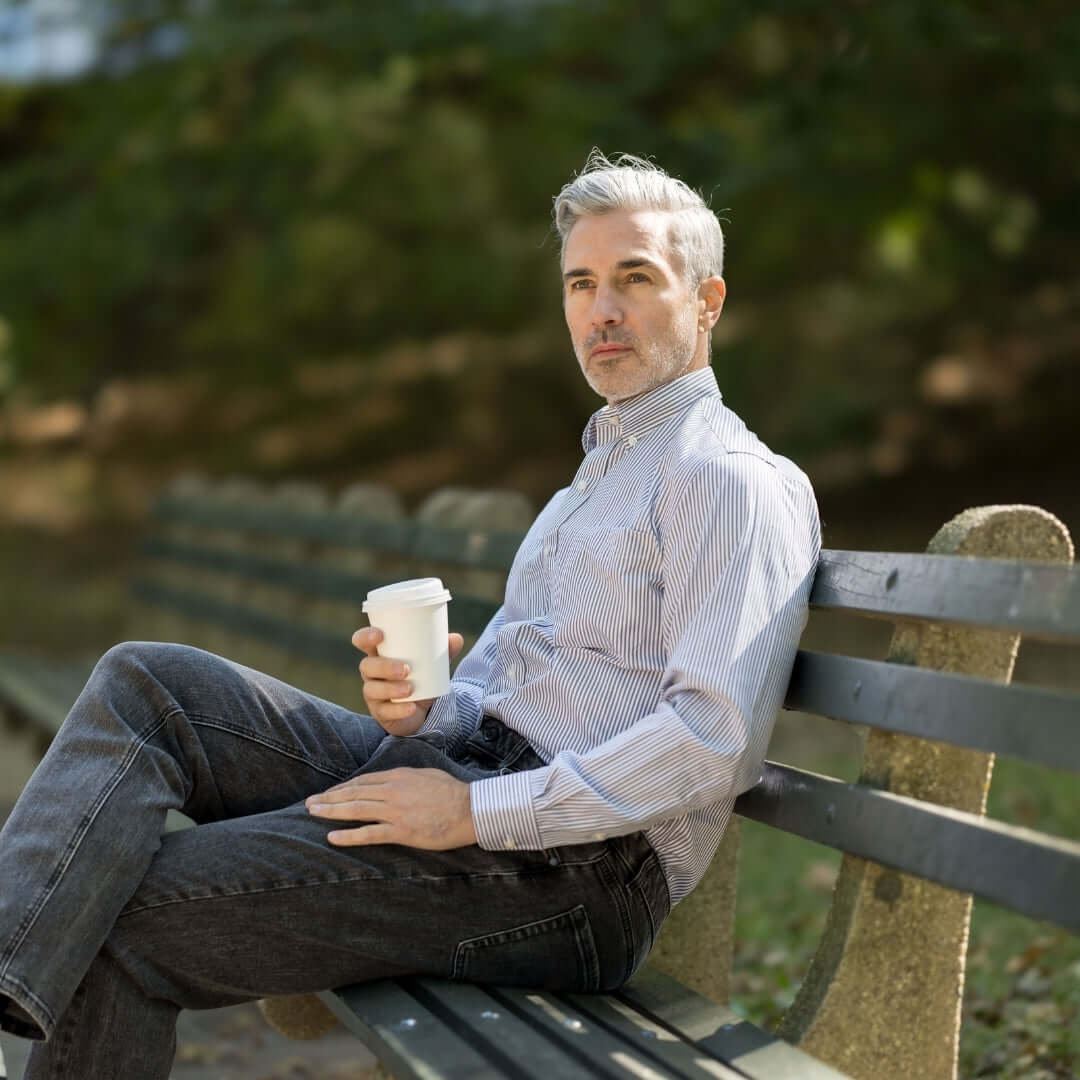 Brown Stripe Long Sleeve Button Down Collar Shirt with Magnetic Closures worn by a man sitting on a bench with a coffee.