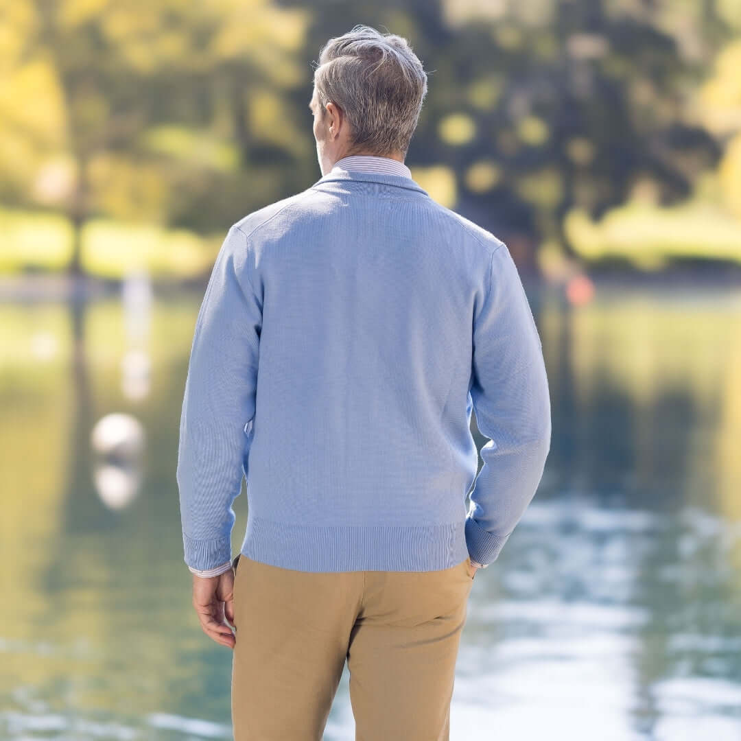 Classic Blue Adaptive Sweater with Magnetic Front Closure with Pocket shown from the back near a serene lake setting.