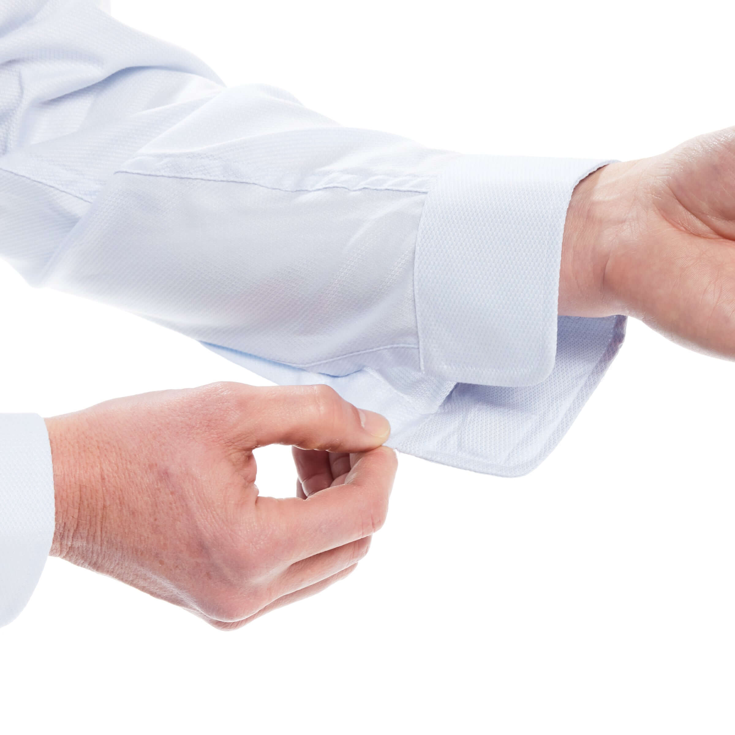 Close-up of hand adjusting the cuff of a light blue long sleeve dress shirt, showcasing adaptive clothing design.
