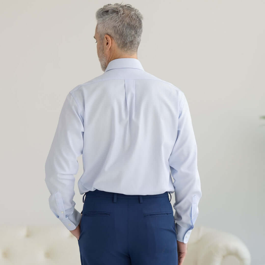 Back view of a man in a light blue 'Ryan' dress shirt, showcasing its adaptive design and traditional fit.