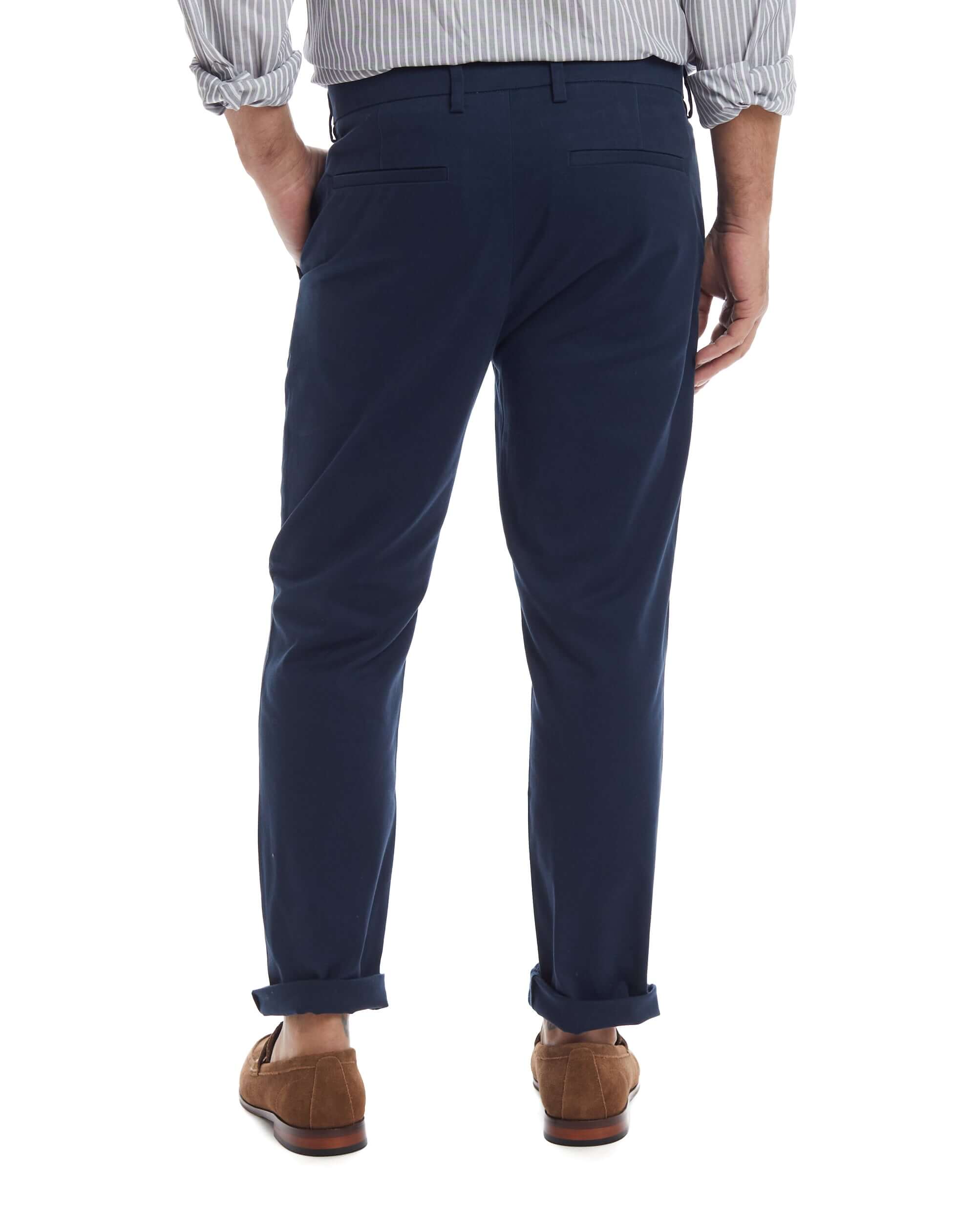 Rear view of a man wearing navy flat front adaptive chino twill pants with magnetic closures, showcasing comfort and style.