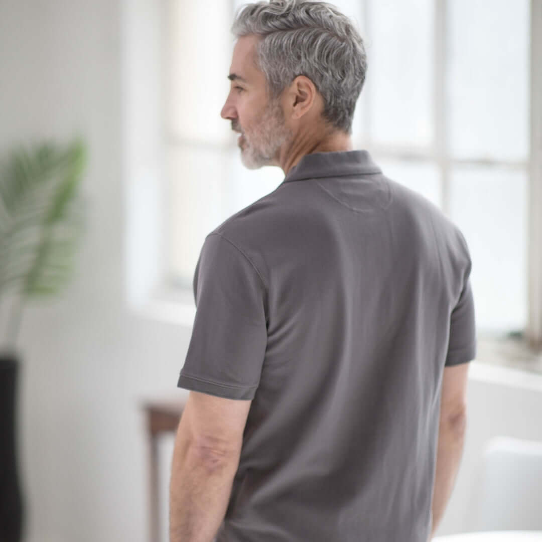 Grey pique knit short sleeve polo with magnetic closures, styled for easy dressing and comfort.