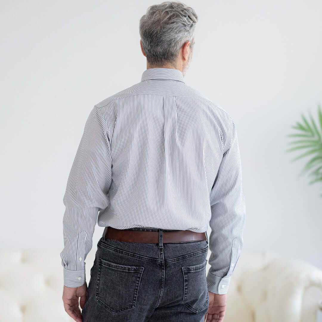 Back view of a man wearing a grey stripe long sleeve button down collar shirt with magnetic closures.