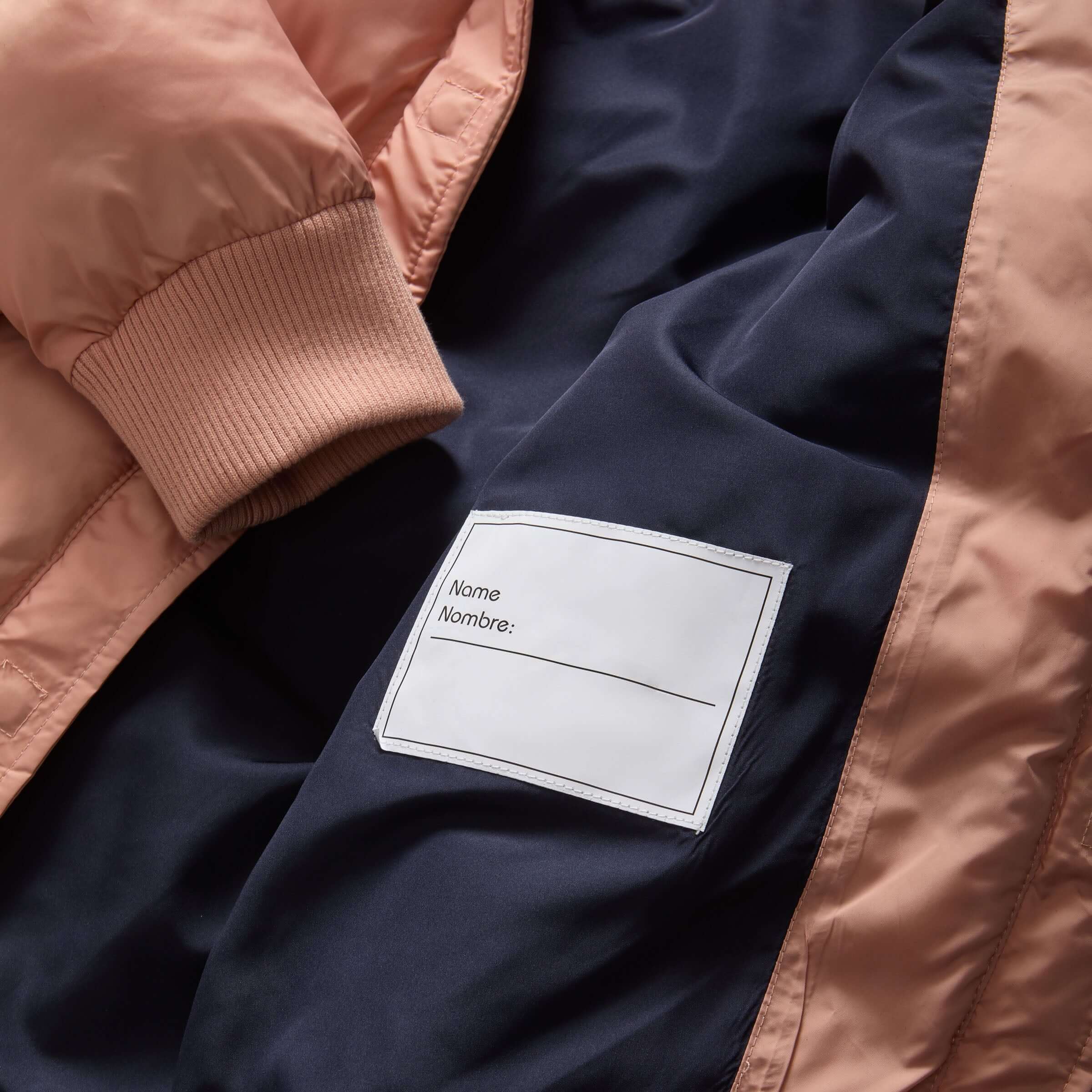 Interior label of MagnaMini kids puffer coat for personalization with a name tag.