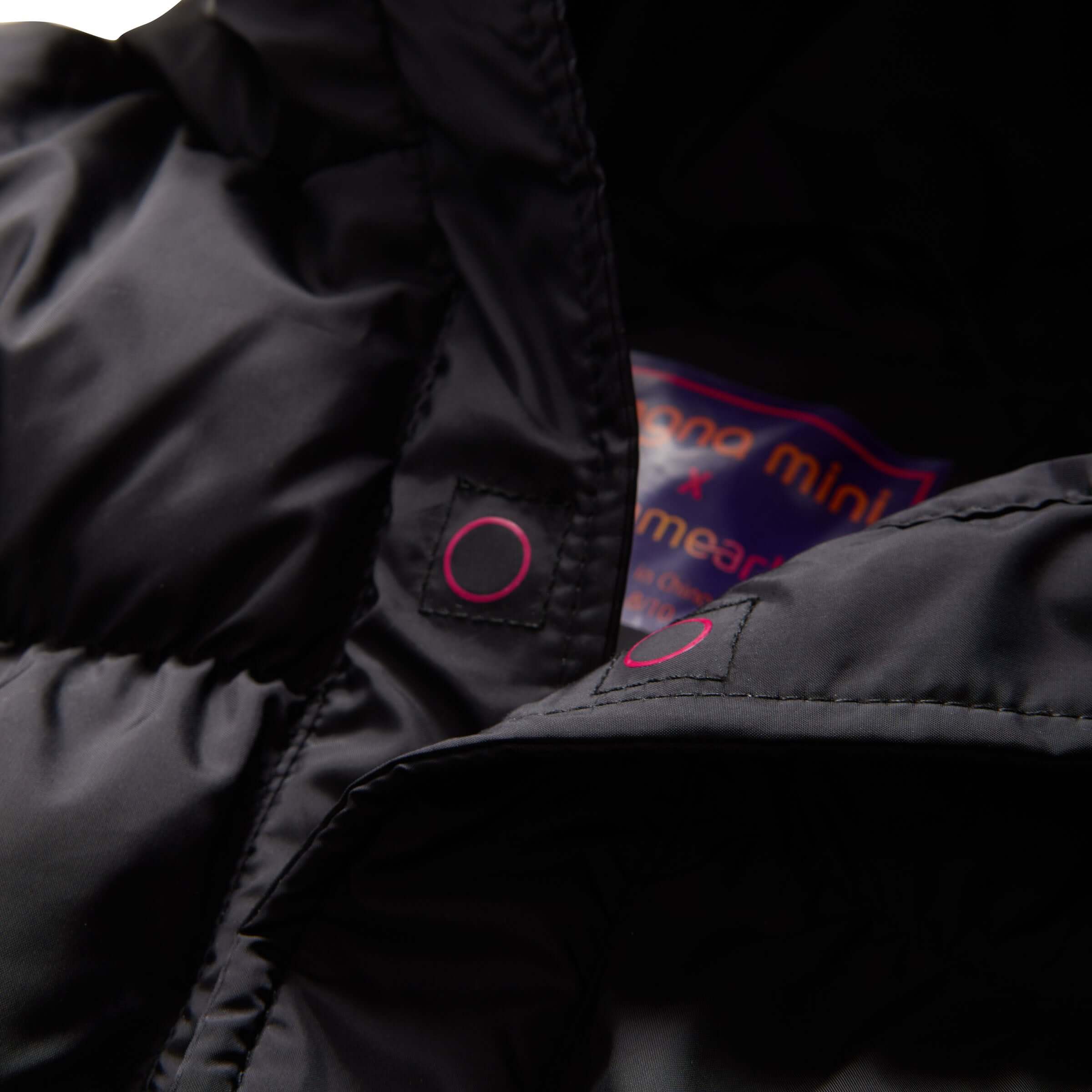 Close-up of MagnaMini black puffer coat's interior magnets and label, showcasing its easy fastening design for kids.