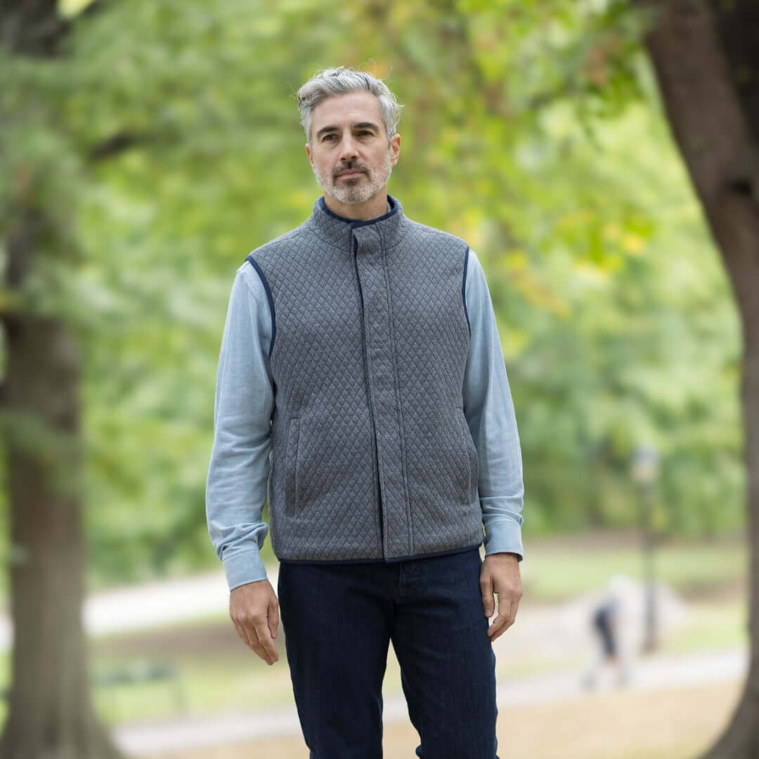Man wearing a gray MagnaReady® Reversible Diamond Quilted Magnetic Button Vest in a park.