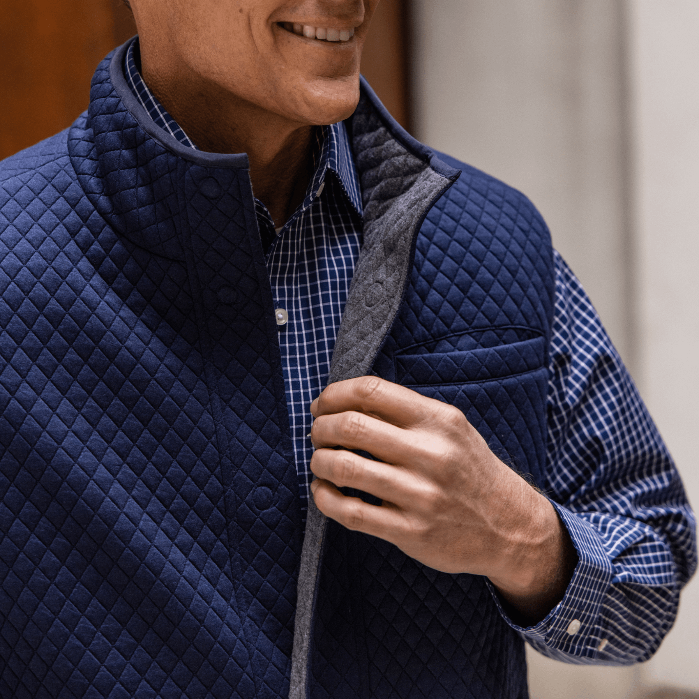 Model wearing a navy MagnaReady® Reversible Diamond Quilted Magnetic Button Vest, showcasing adaptive style and comfort.
