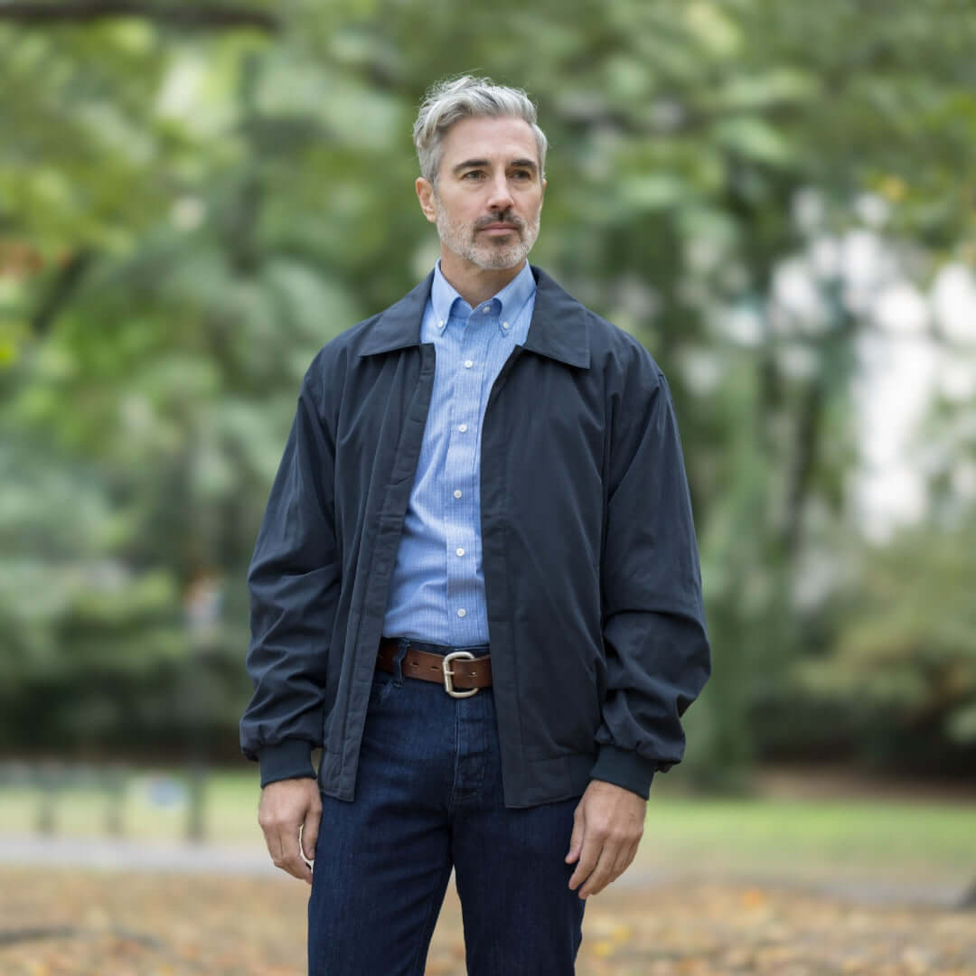 Stylish man wearing MagnaReady® X Weatherproof Navy Golf Jacket, perfect for accessibility and comfort in outdoor activities.