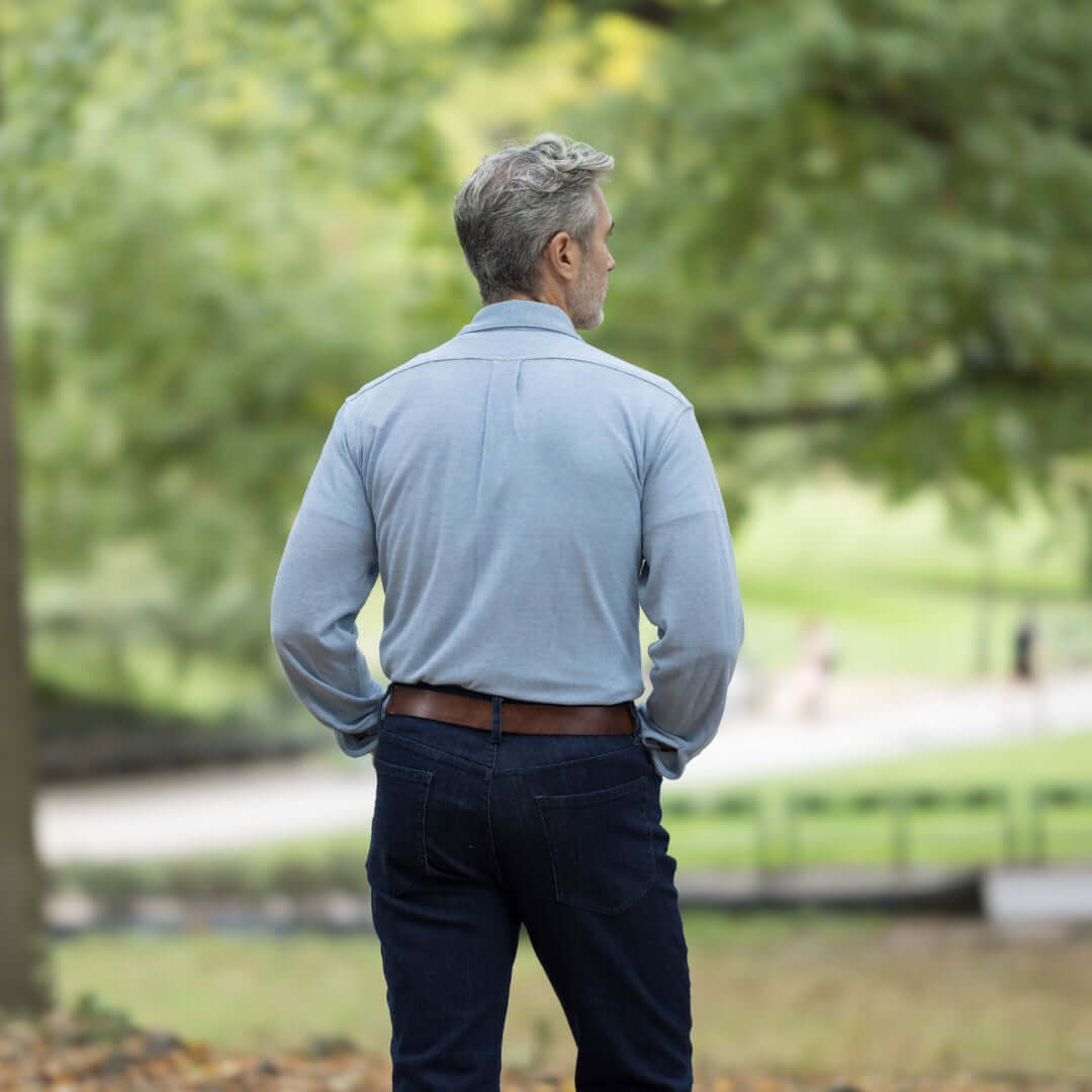 Man wearing a sky blue long sleeve oxford shirt with MagnaReady technology in a natural outdoor setting.