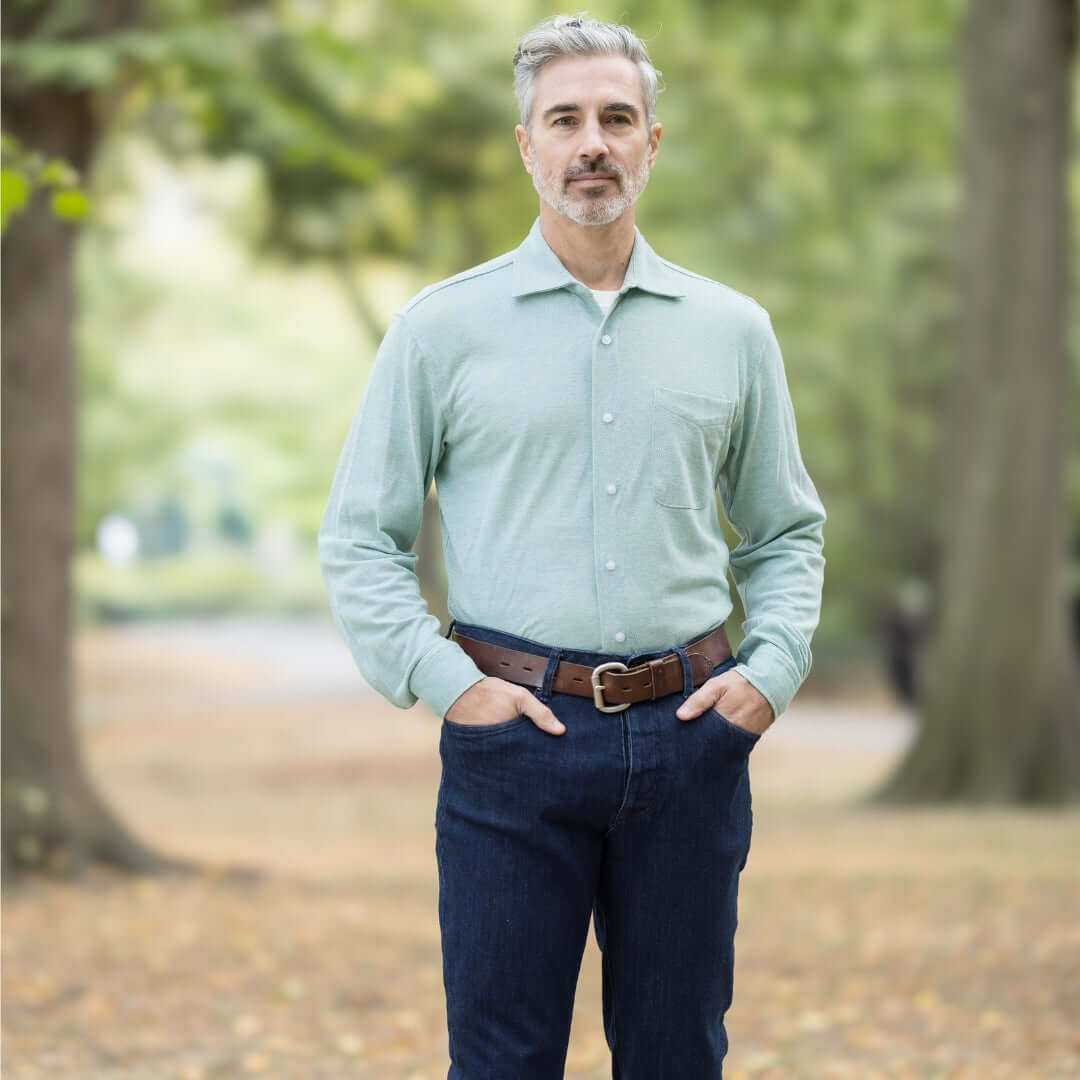 Man wearing an Ivy Green Magnetic Front Knit Oxford Shirt in a park setting, showcasing a stylish and comfortable look.