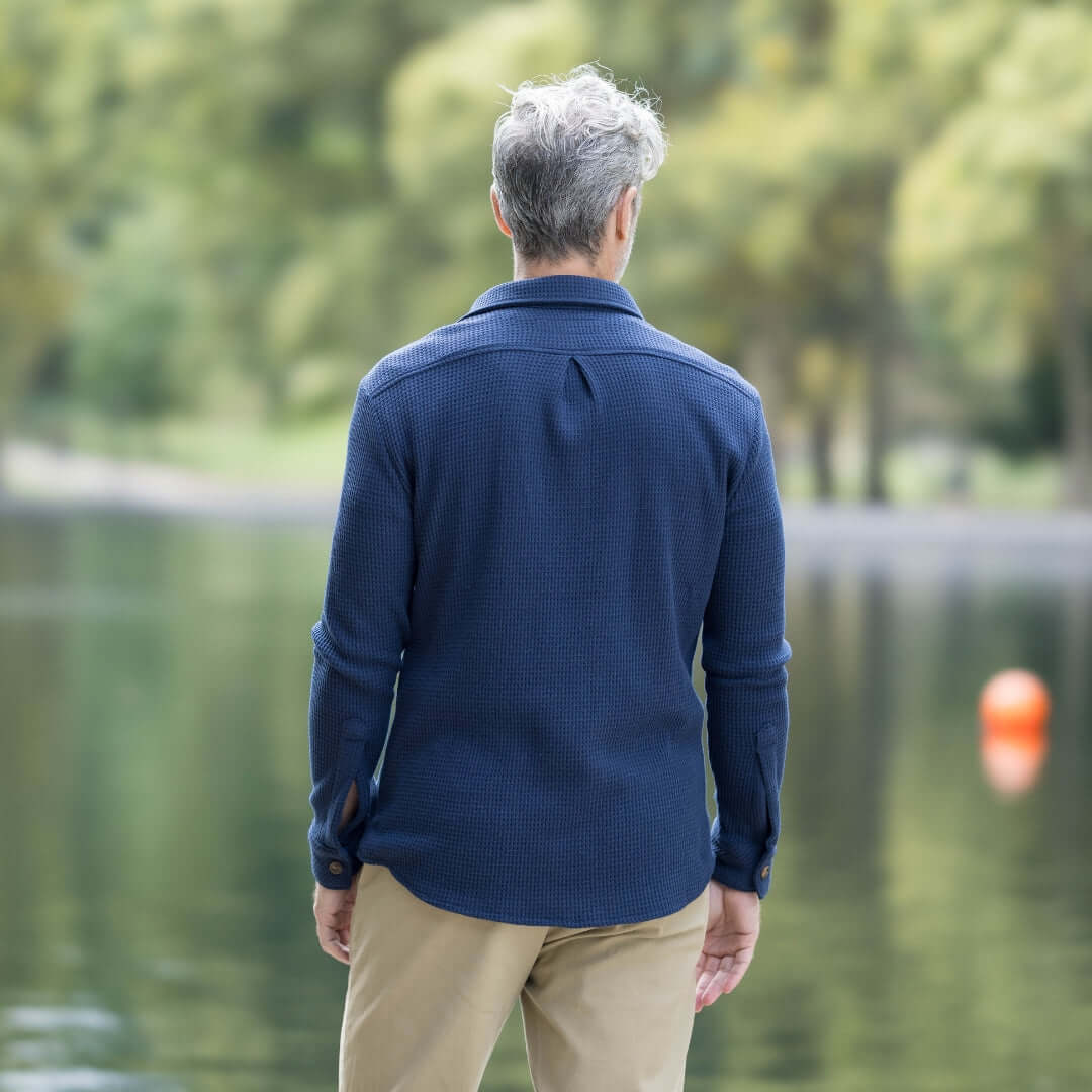 Man wearing a navy Magnetic Front WaffleWeave Casual Shirt by a lake, showcasing the back view and relaxed fit.