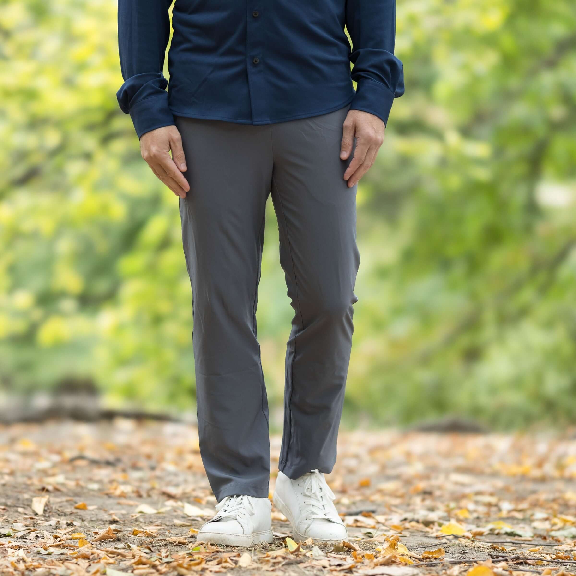 Men's charcoal grey elastic waist adaptive track pants, styled for comfort and versatility in outdoor setting.