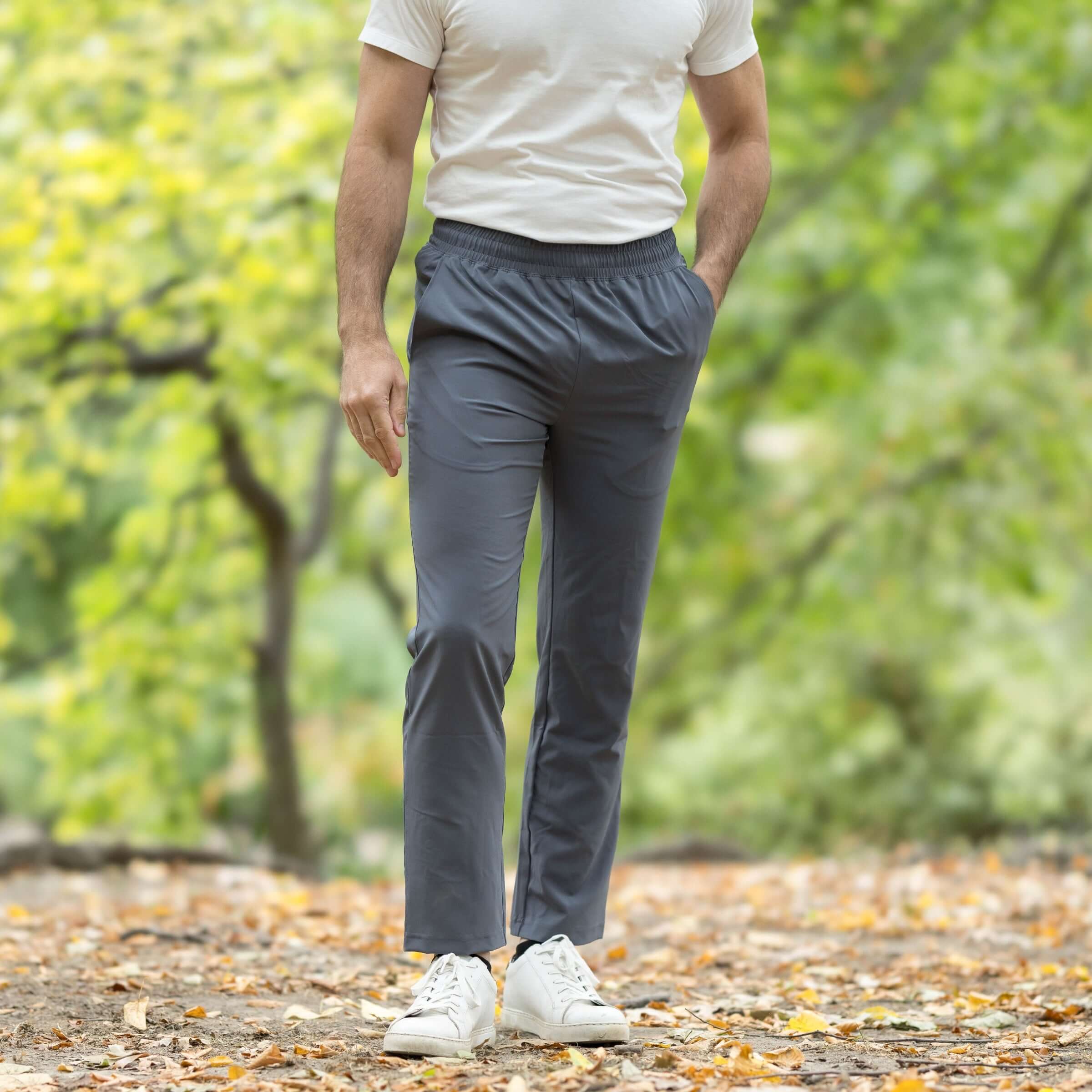 Men's charcoal grey elastic waist adaptive track pants in a casual outdoor setting.