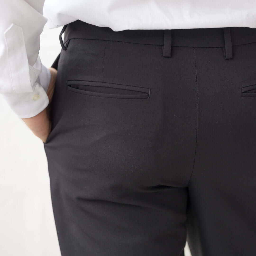 Back view of Nautica® x MagnaReady® Adaptive Fly Stretch Dress Pant in black, showcasing elegant pockets and tailored fit.
