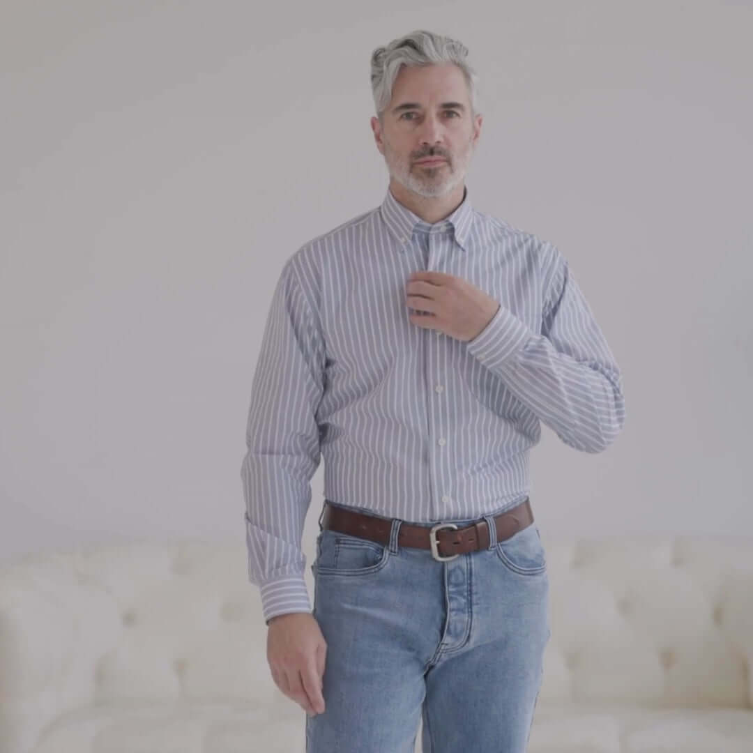 Man in a grey stripe long sleeve button-down shirt with magnetic closures, standing against a light background.