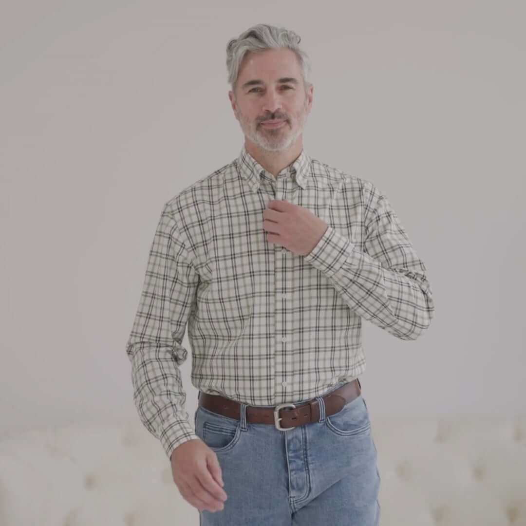 Man wearing a green and black plaid long sleeve button-down shirt with magnetic closures, designed for easier dressing.