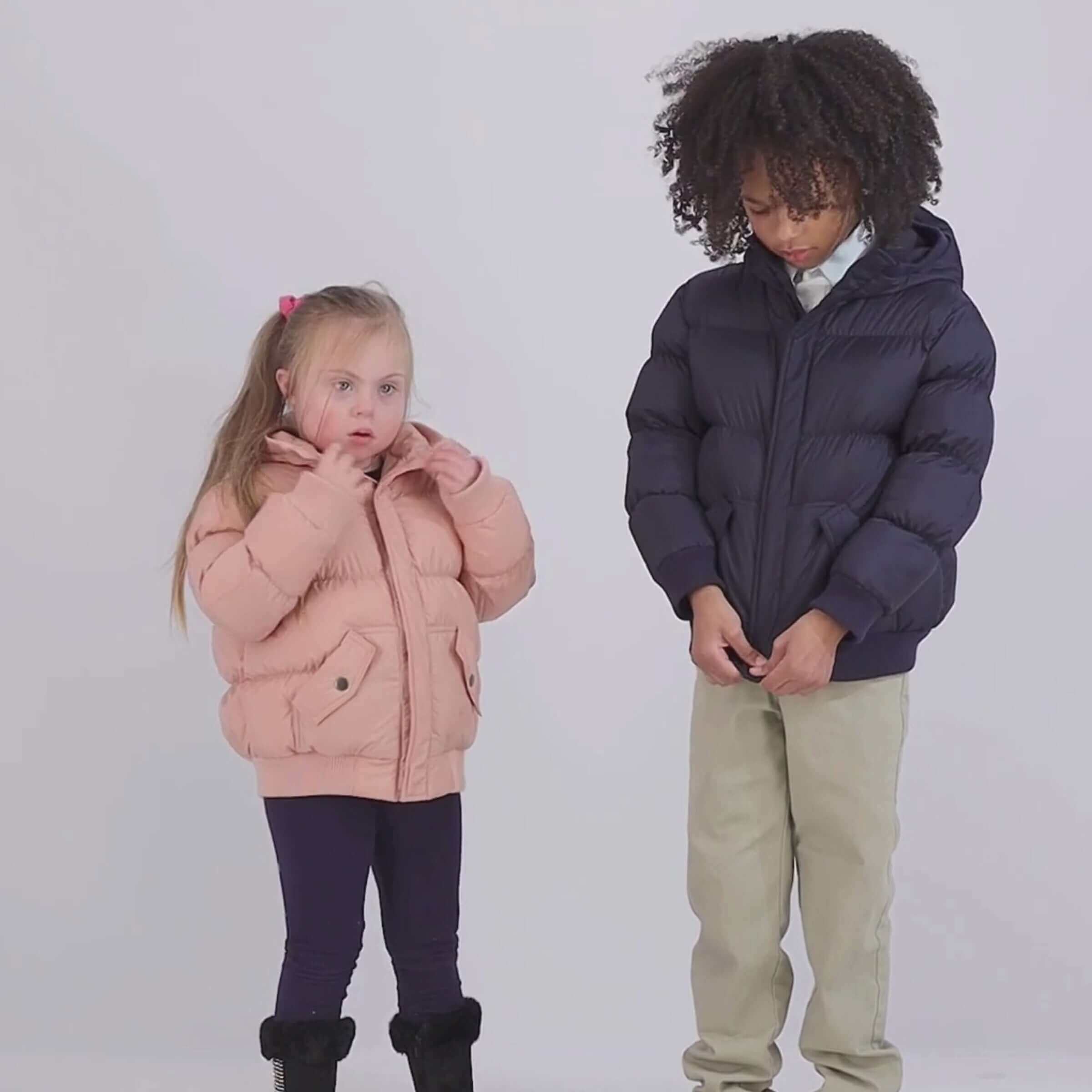 Kids wearing cozy puffer coats; one in pink, one in navy, showcasing comfort and style.