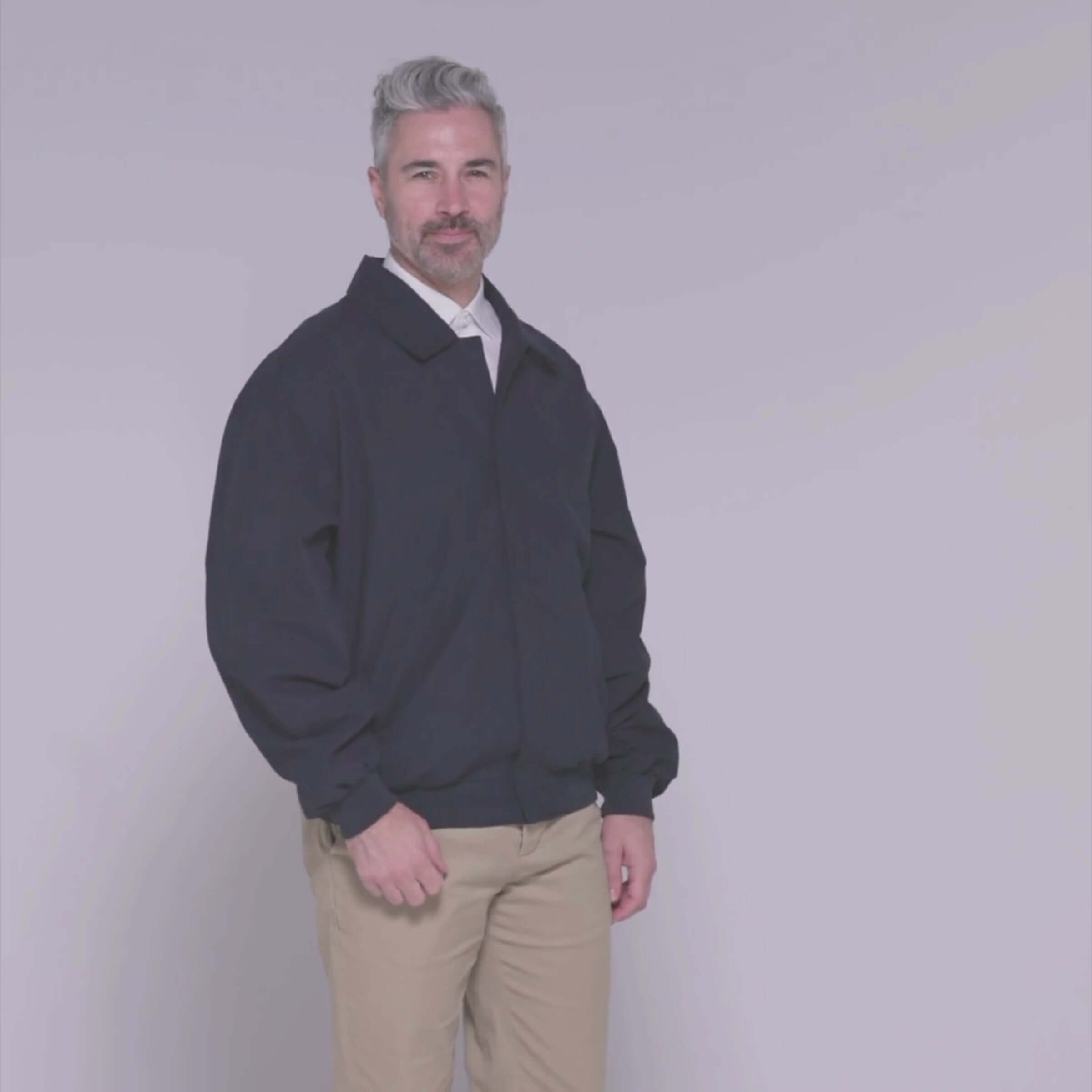Model wearing the MagnaReady® weatherproof navy golf jacket, showcasing its stylish and adaptive design.