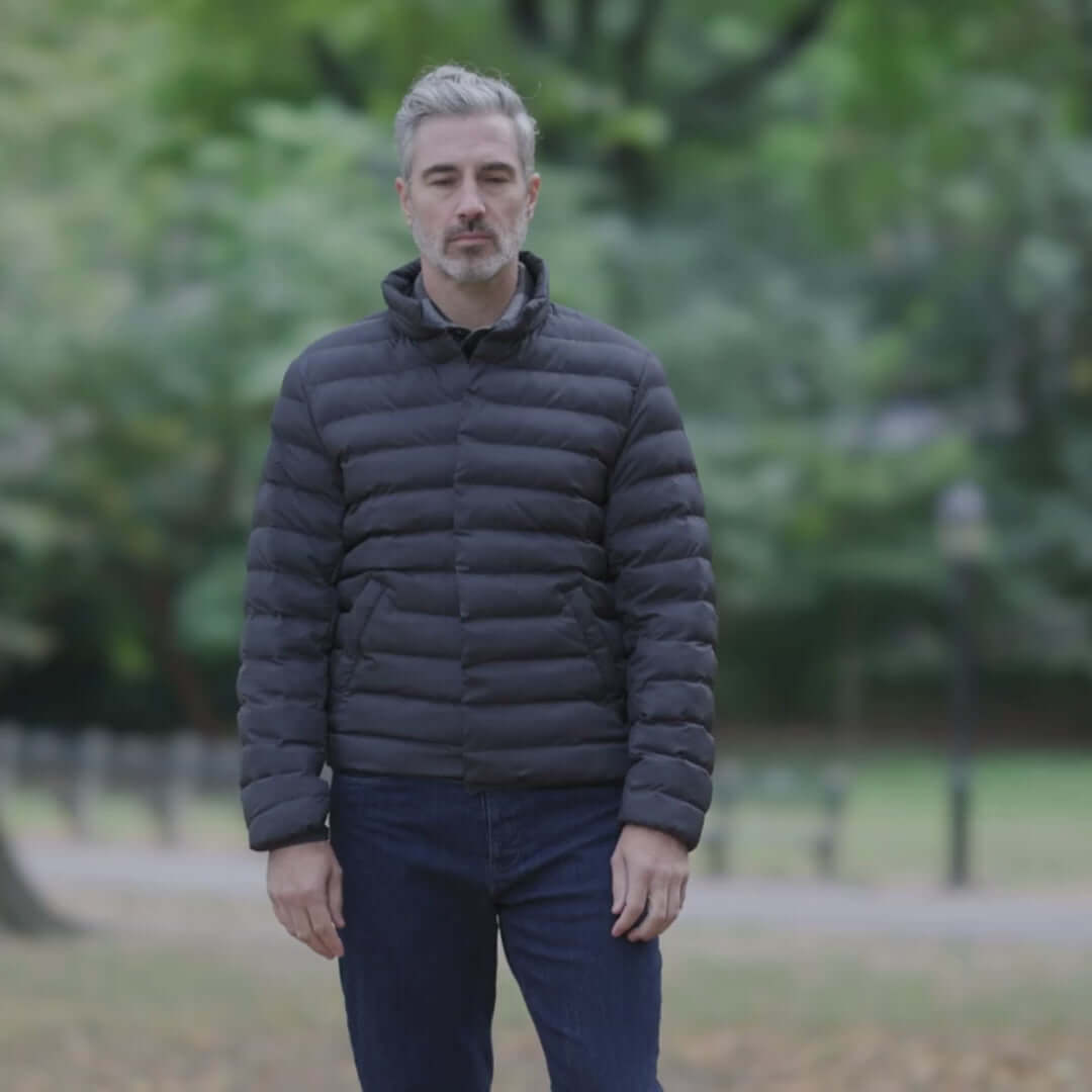 Model wearing a Weatherproof x MagnaReady magnetic front water-resistant puffer jacket in outdoor park setting.