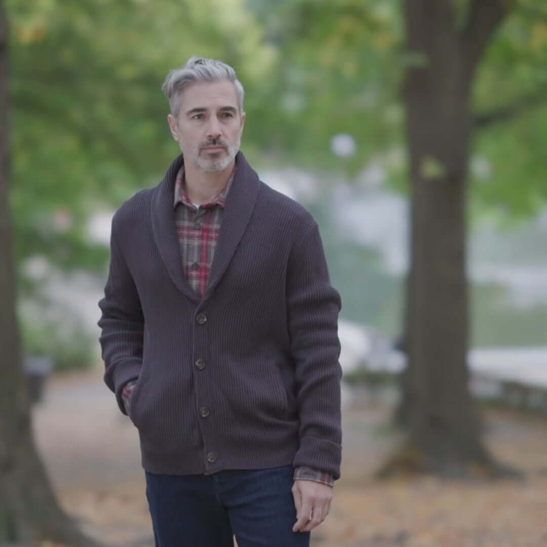 Man wearing an adaptive ribbed cotton shawl collar cardigan with magnetic buttons in charcoal, walking outdoors.