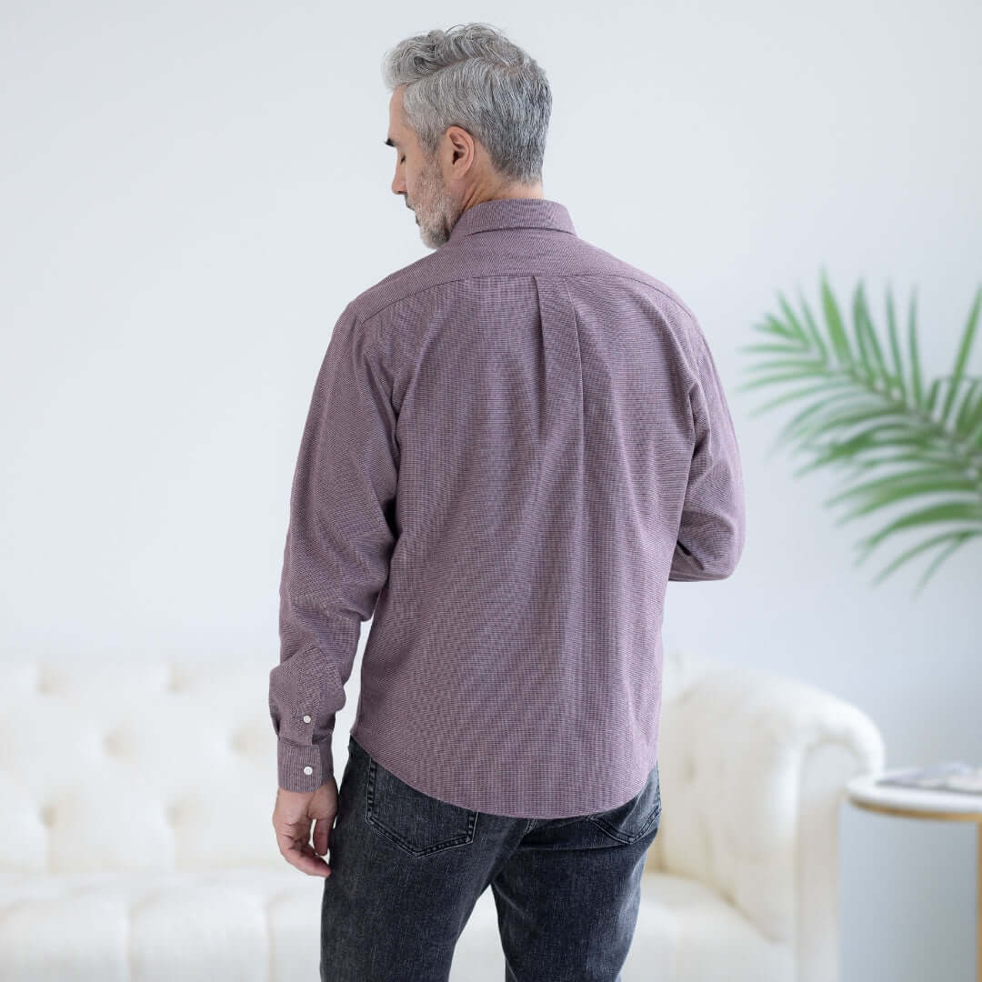 Back view of a man wearing a red and grey long sleeve button-down shirt with magnetic closures.