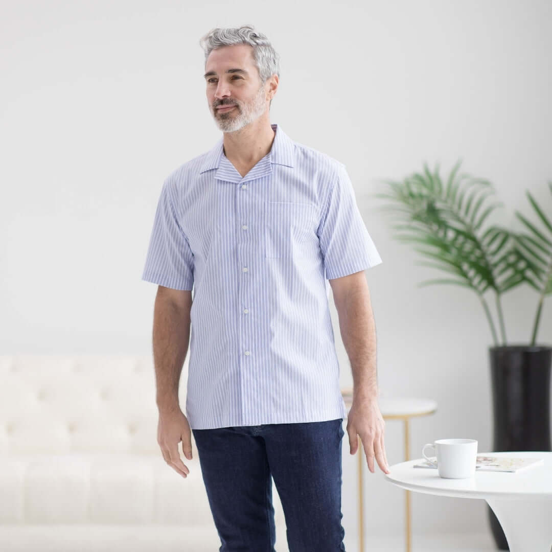 Man wearing a short sleeve untucked blue stripe 'Landry' camp shirt with magnetic closures, stylish and adaptive.