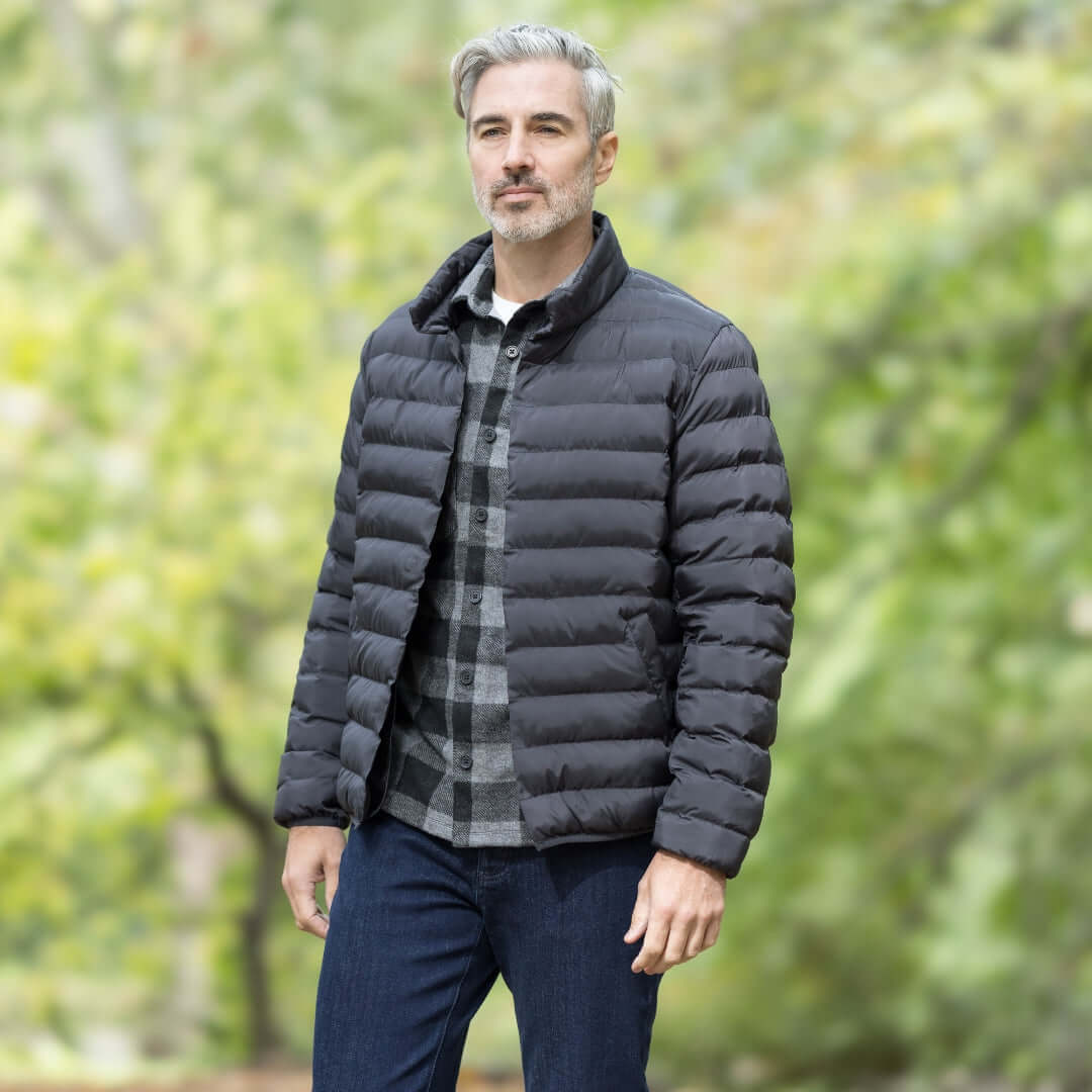 Man wearing Weatherproof x MagnaReady magnetic front black puffer jacket in a natural outdoor setting.
