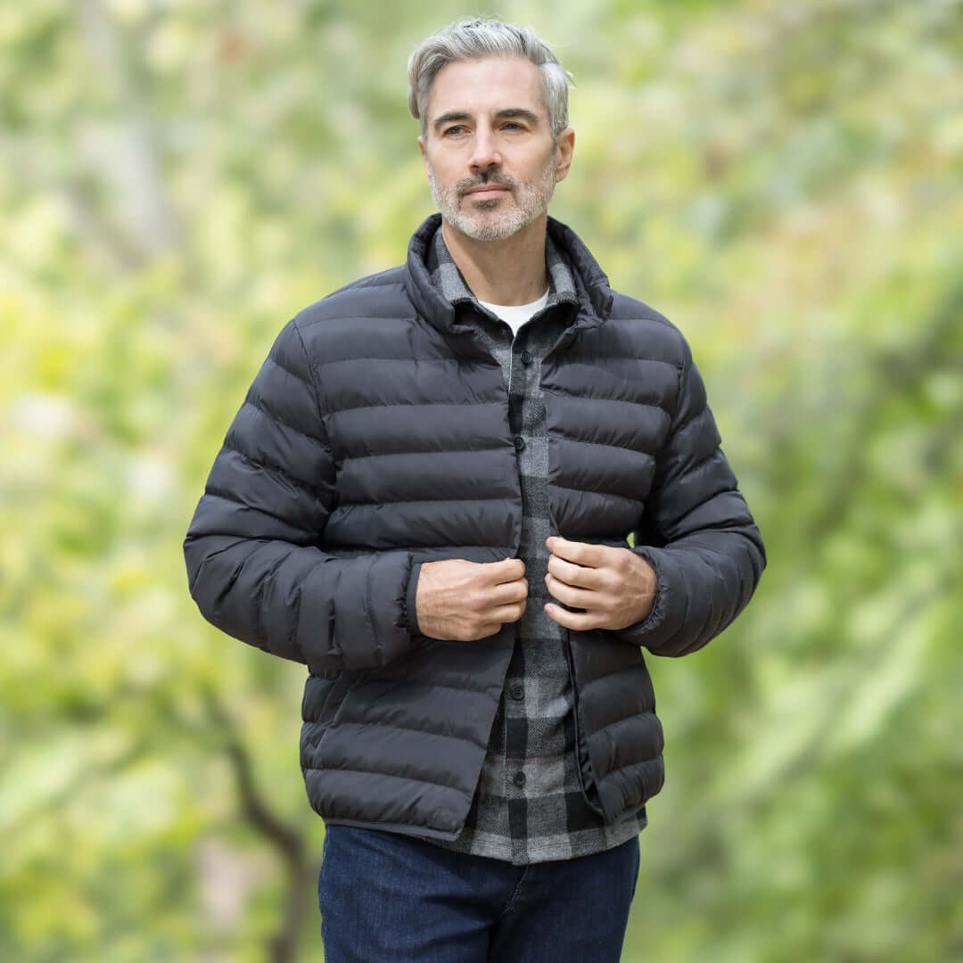 Man wearing Weatherproof x MagnaReady black puffer jacket, showcasing sleek design and magnetic closure technology.